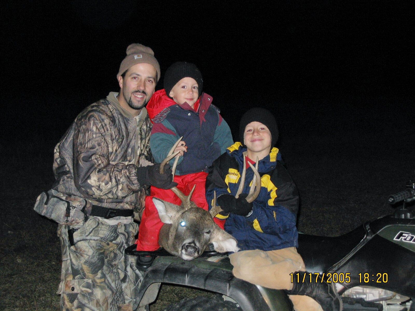 Boys helping Dad recover archery buck